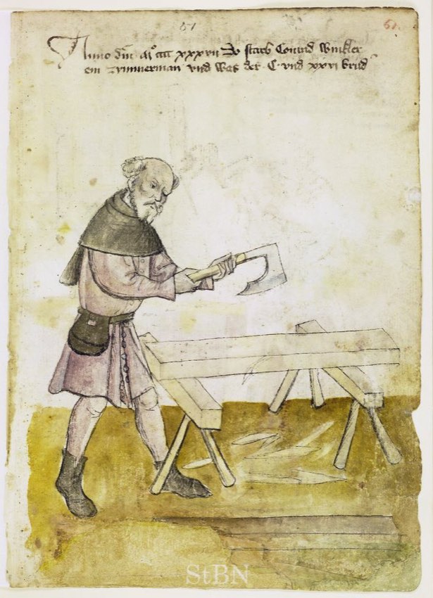 A carpenter squares a wooden beam with a broadaxe on a pair of sawhorses.